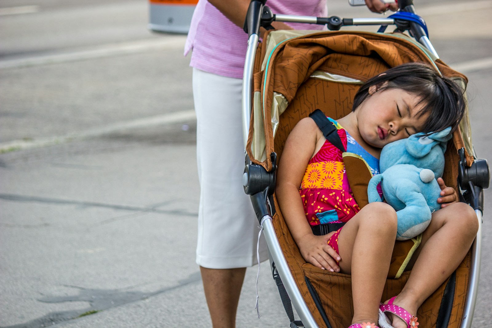 baby in pink shirt lying on stroller
